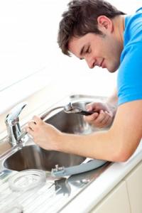 a tech installs a flow control device on a kitchen faucet